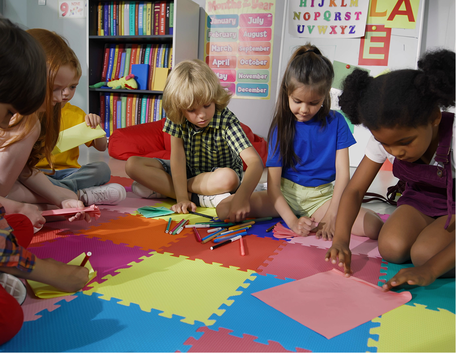 Children coloring on colorful floor mats.