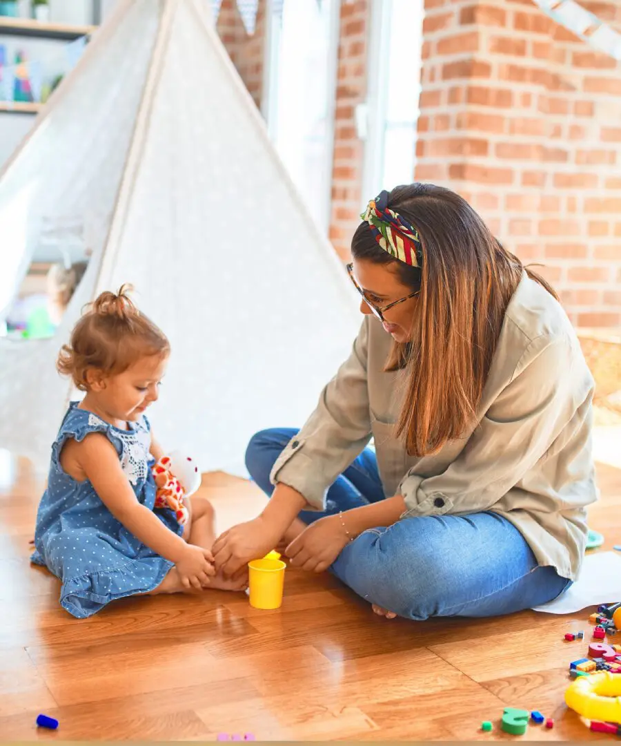 Woman and child playing with toys indoors.